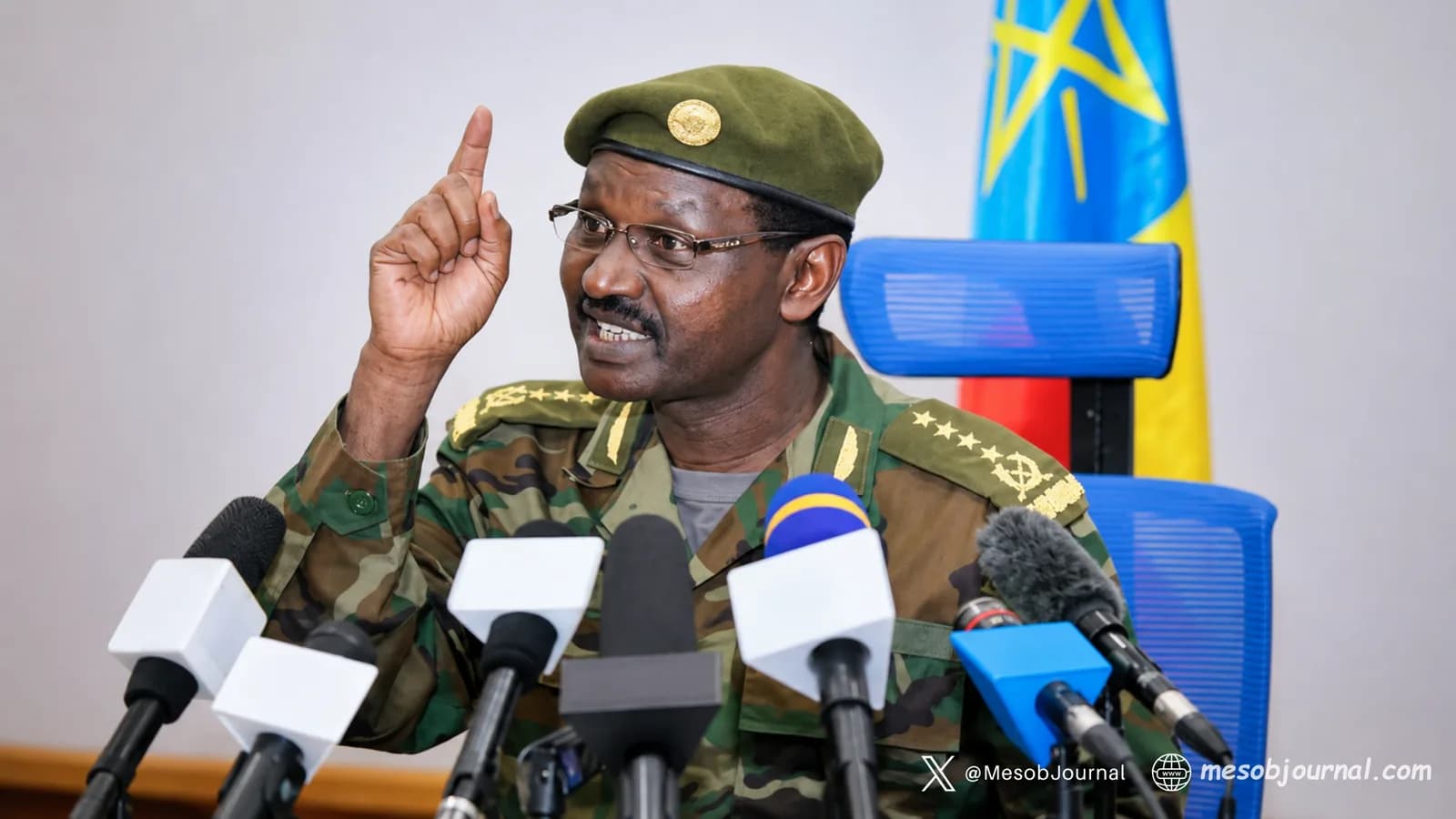 Military officer speaking to reporters at a press conference.